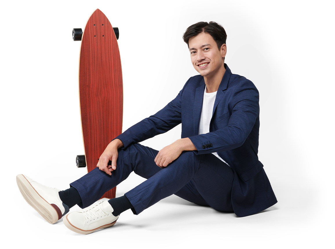 Junger Mann im Anzug mit Skateboard